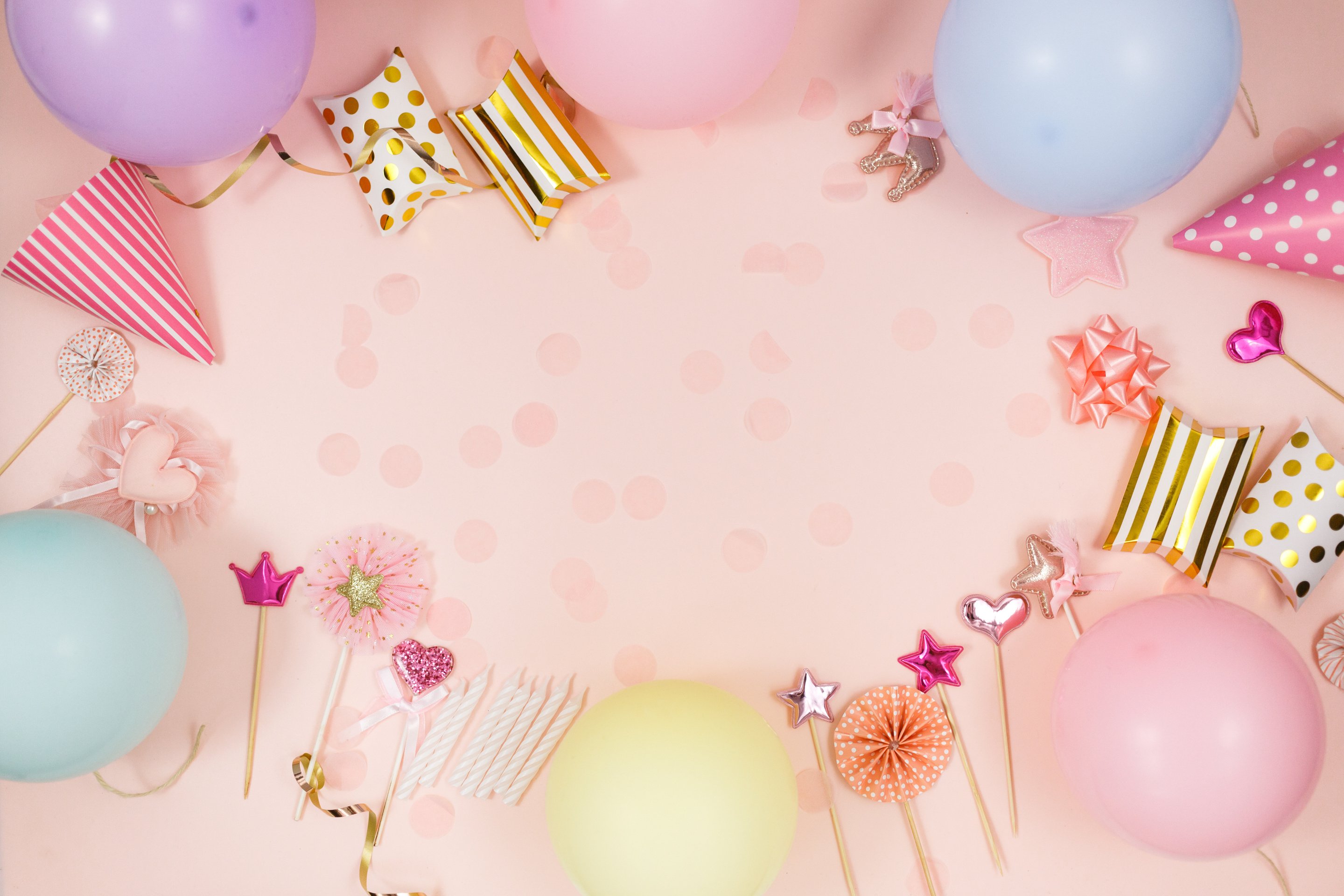 Background for happy birthday celebration or party. Group of colored balloons , confetti, candles, ribbons on pastel pink background. Mock up with copy space, place for text